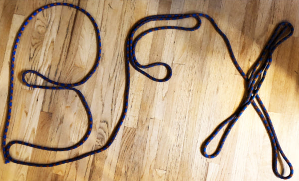 letters BFX spelled out in a length of blue climbing rope on a oak hard wood floor