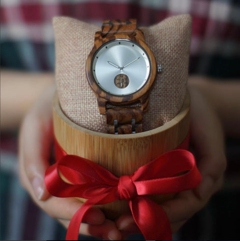 hands holding wooden watch in gift box