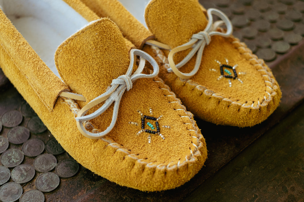 Warm cozy moccasin slippers with beading and fleece lining.
