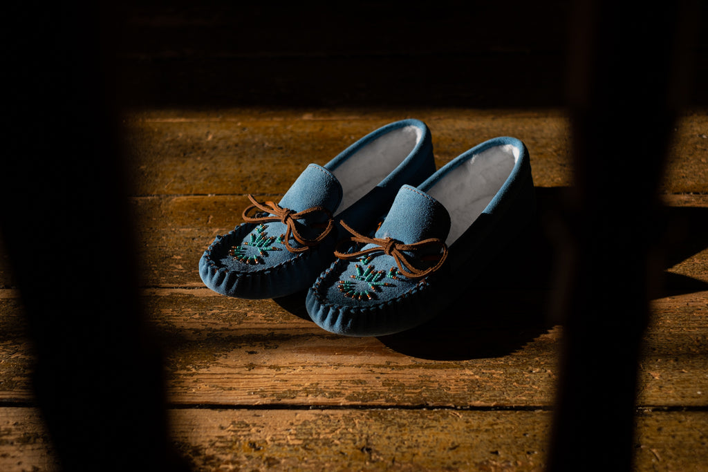 looking through a window on a dreary day at a pair of blue moccasins