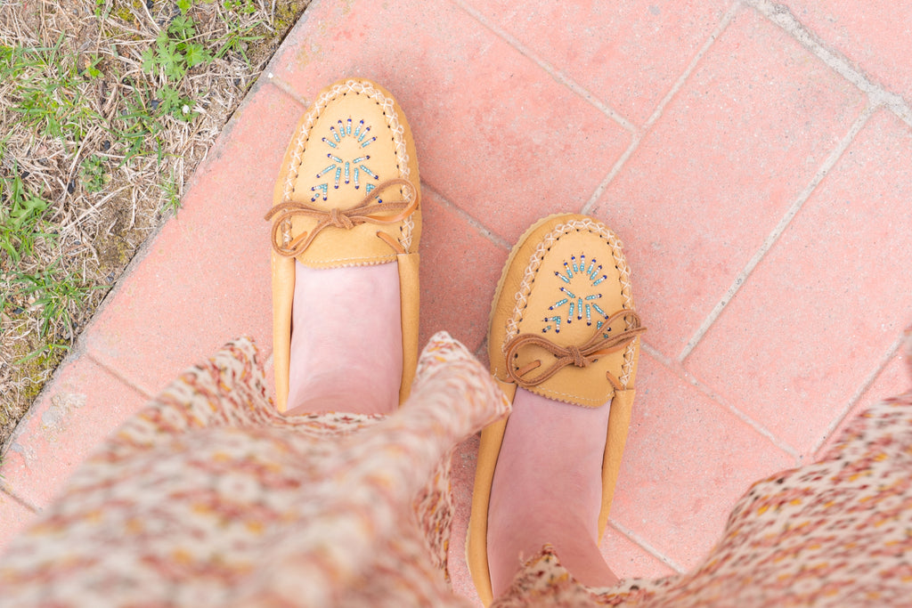 outside on a sunny day with a pair of authentic Native American made beaded moccasins