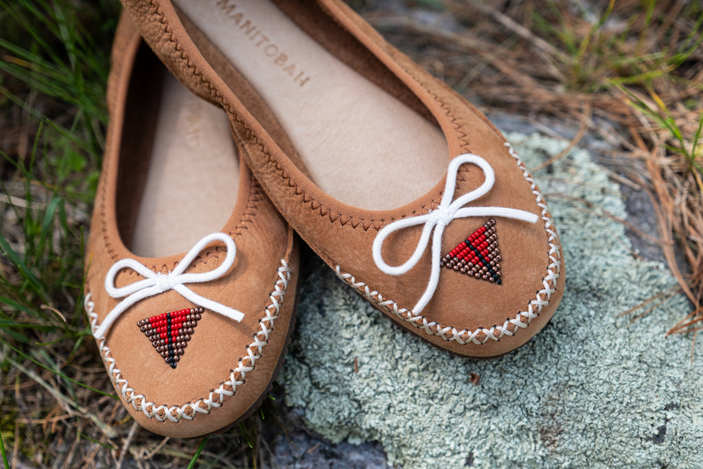 Native-style beadwork by Beadwork designed by Nimíipuu artist Mikailah Thompson on a pair of butterfly flat moccasin shoes.