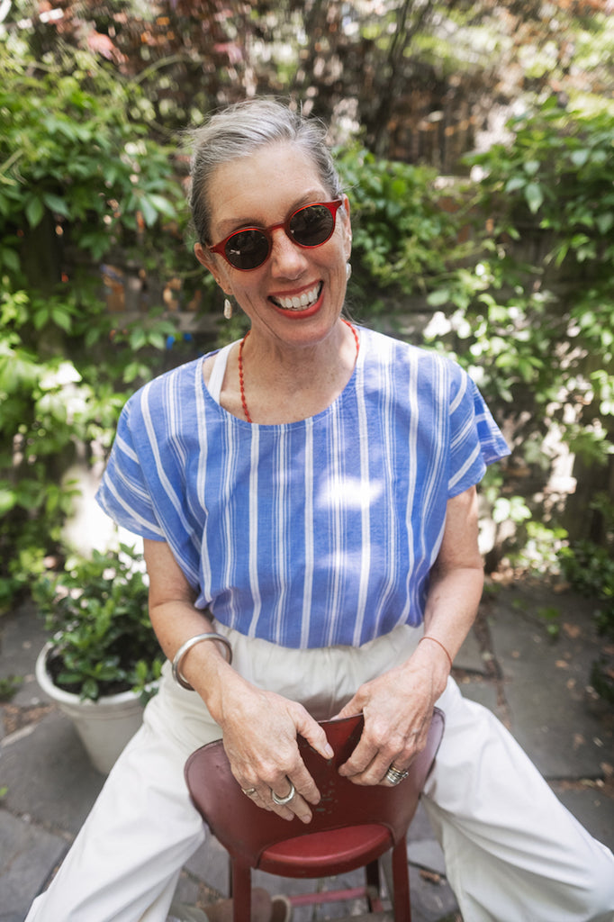 Susannah Thompson sitting in a garden wearing the M.PATMOS Milton Top and Elsa Pants