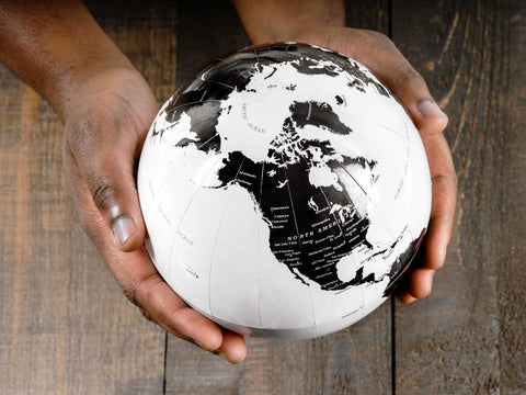 white and black world globe held in hands