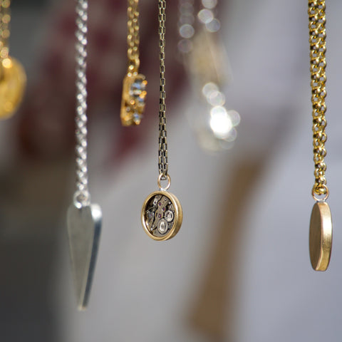 gold and silver necklaces dangling in air