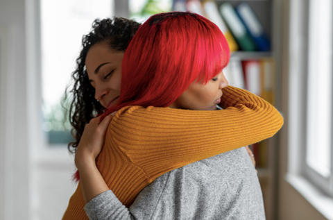 Two women hugging each other in support.