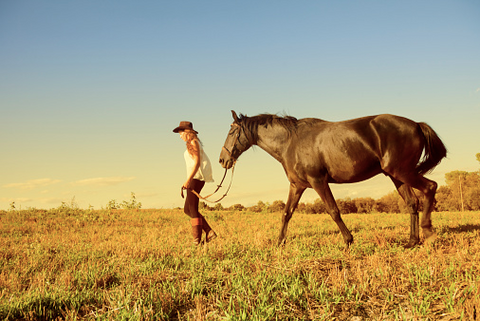 Woman and her horse walking in the nature.