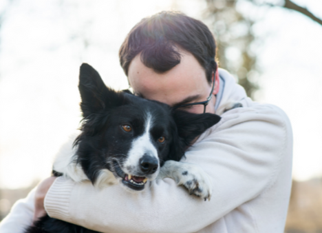A picture of a man hugging his dog.