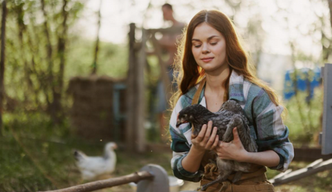 Photo of a woman with a chicken in her arms.