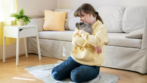 A picture of a hugging her rabbit.