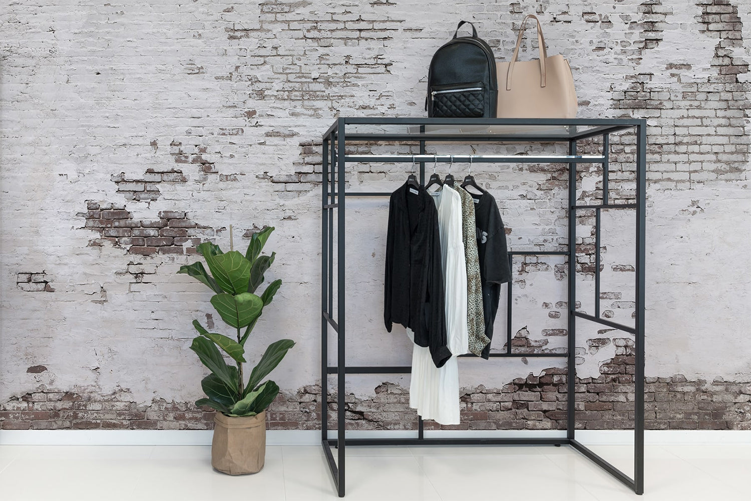 Industrial Ivory, Mural Wallpaper featured on a wall of a room with marble flooring and has clothing rack and planters beside it