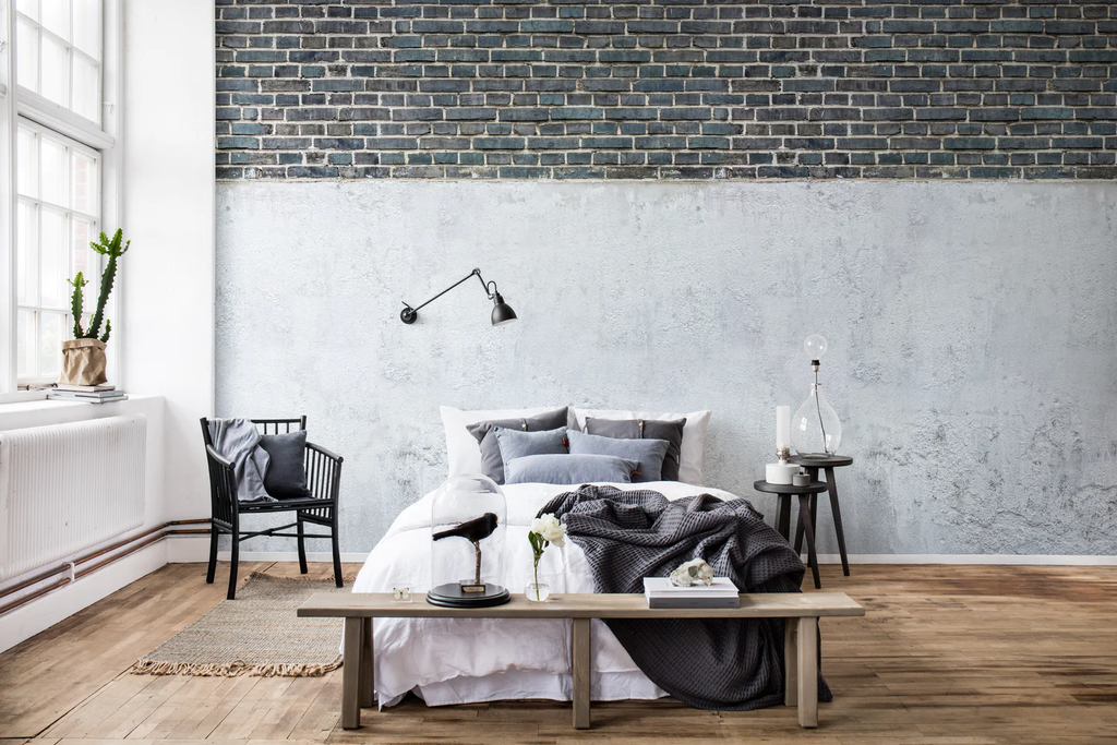 Top Brick Concrete Wall, Faux Texture Wallpaper featured on a wall of a bedroom with black, white, and grey pillows and sheets