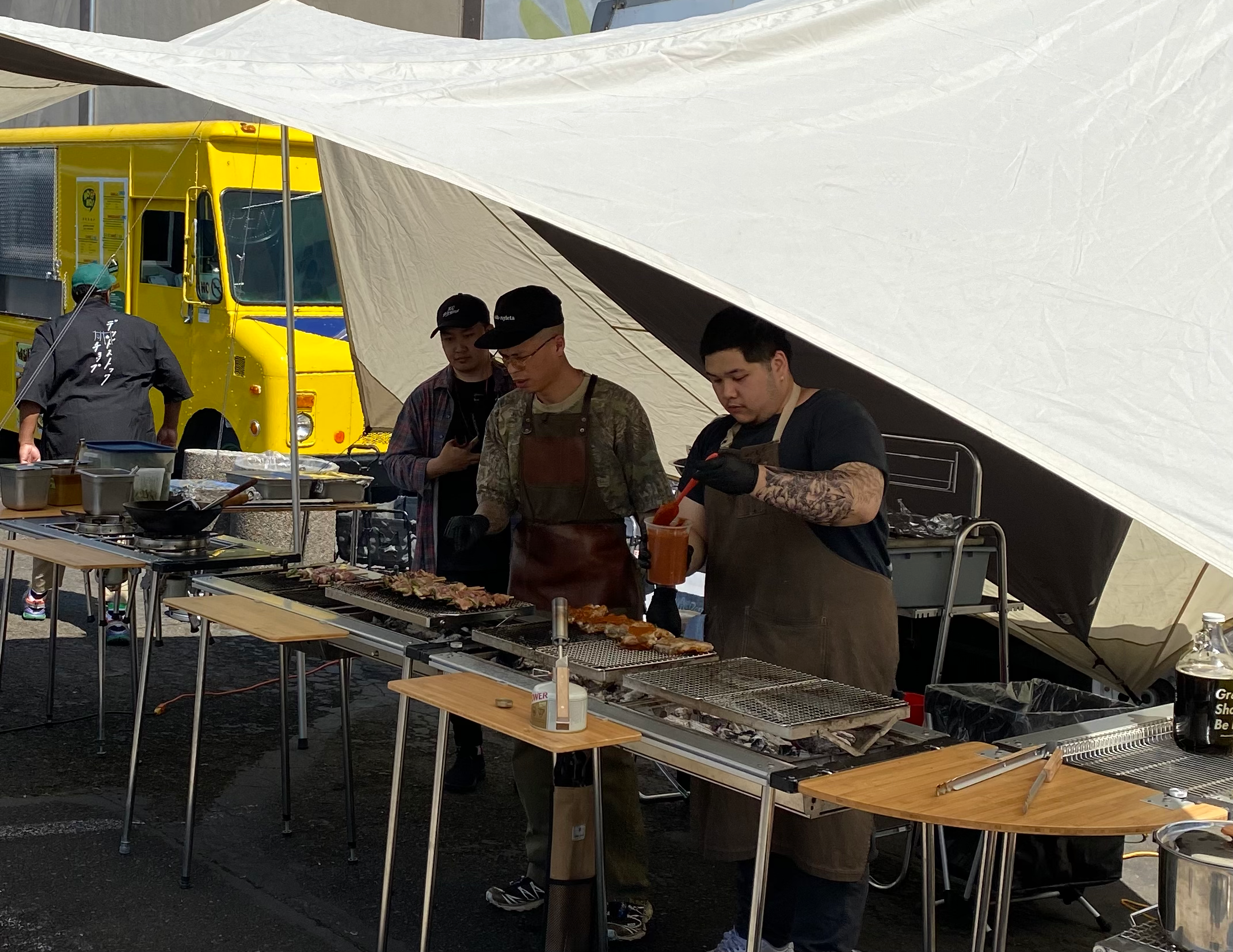 Matta & Co cooking up a delicious meal on an IGT setup underneath a Snow Peak ivory tarp. 