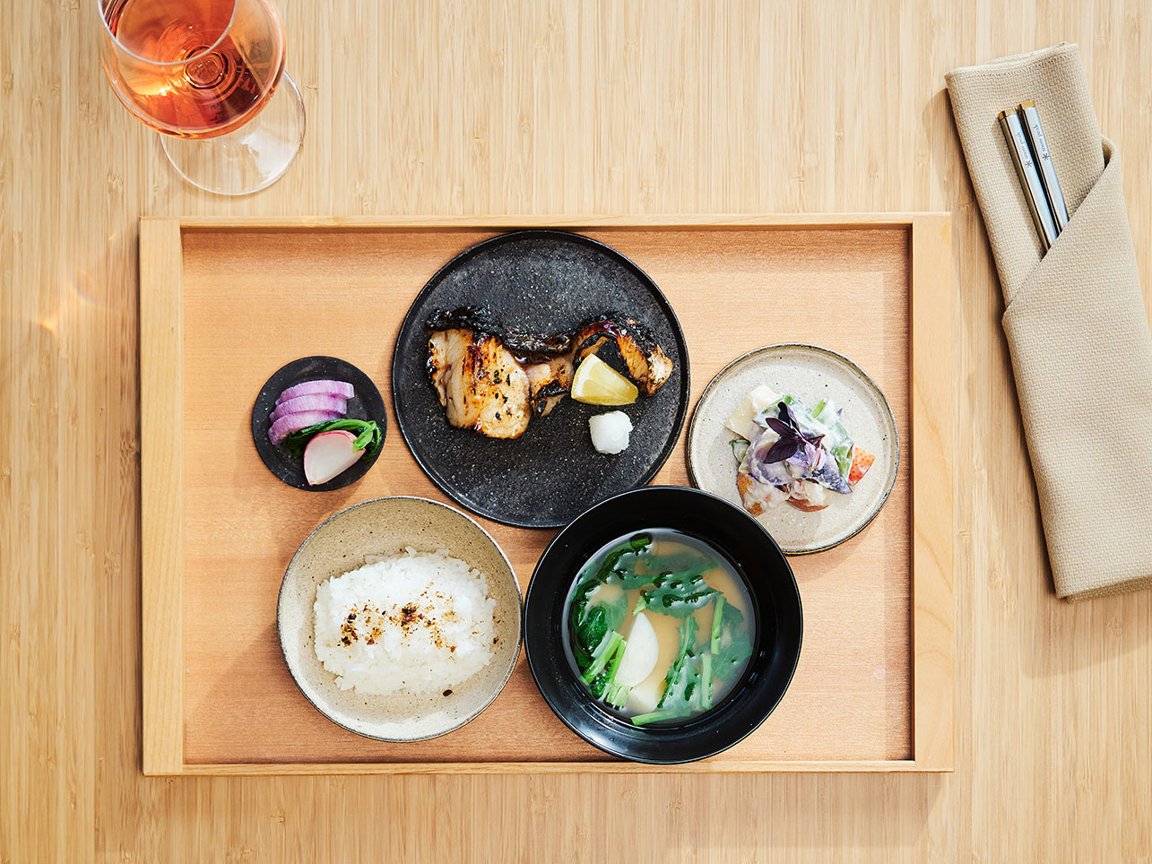 Beautifully plated food on a bamboo tray.