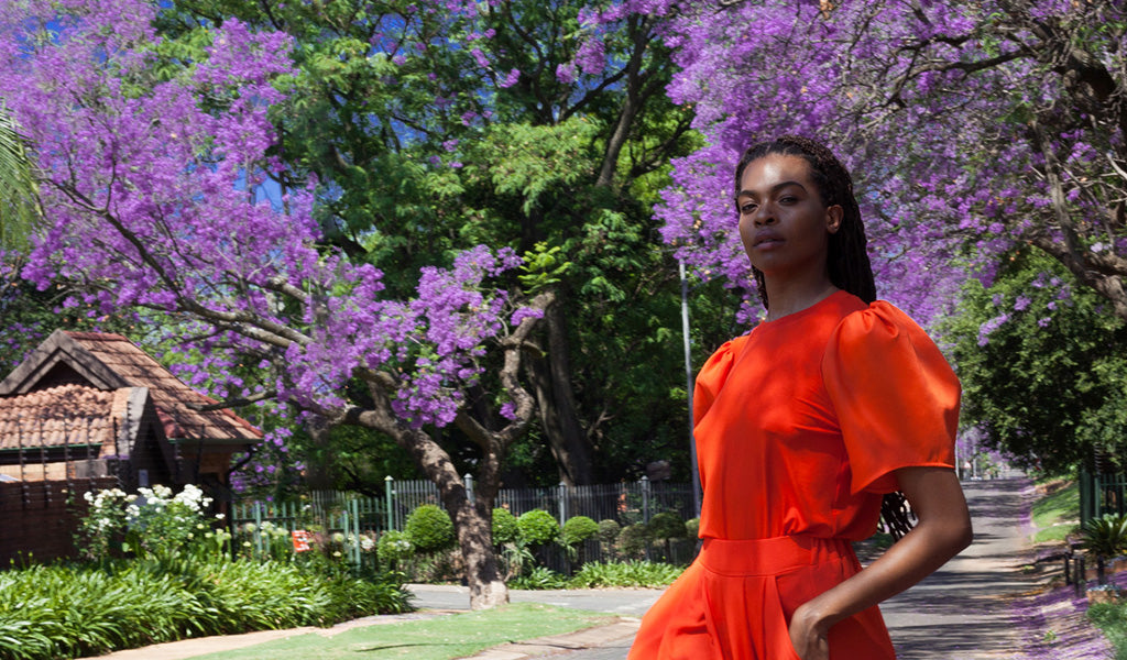 Model against the backdrop of purple Jacaranda trees in Pretoria