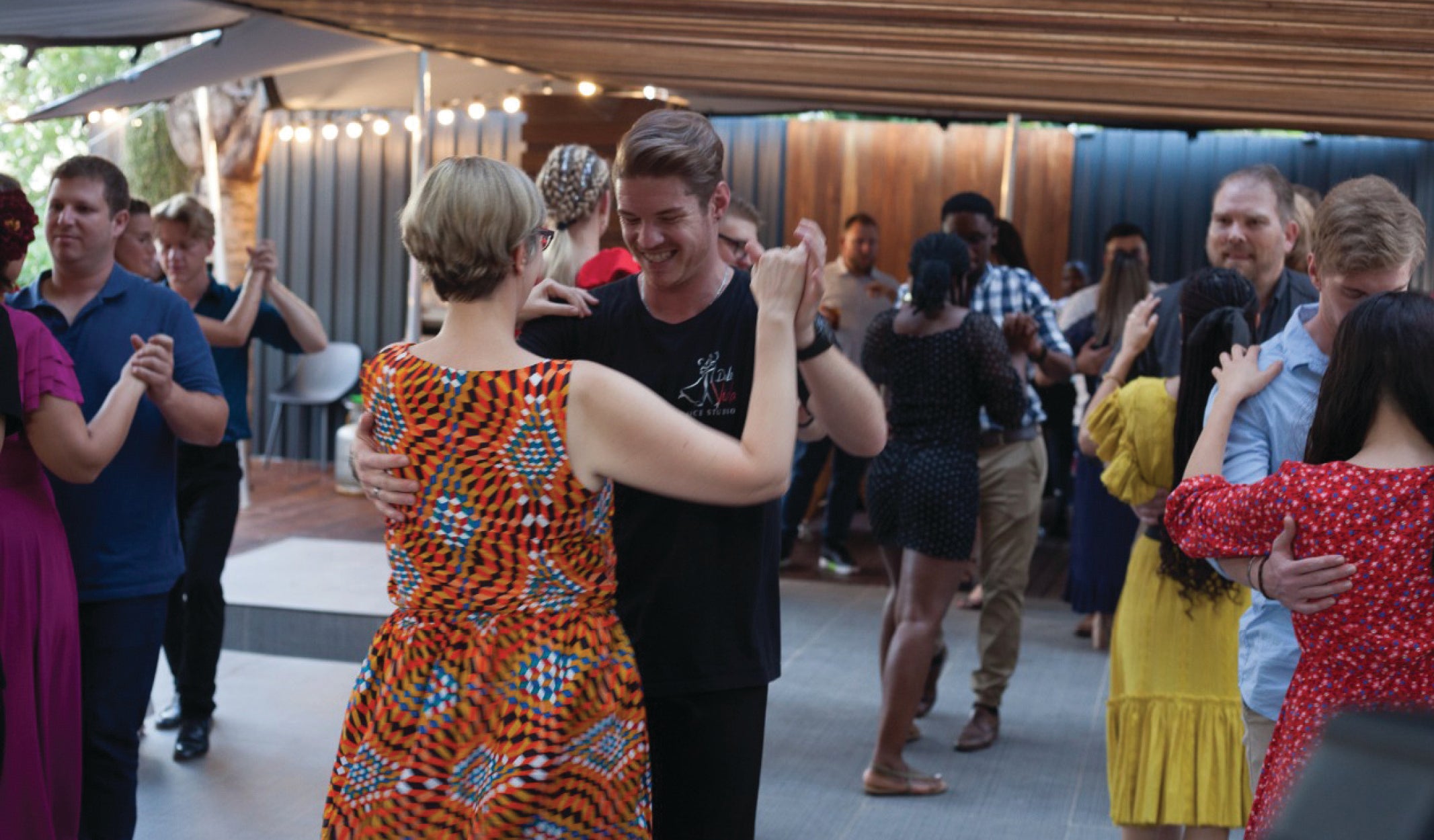 A group of happy people learning to dance at Milner Fashion House