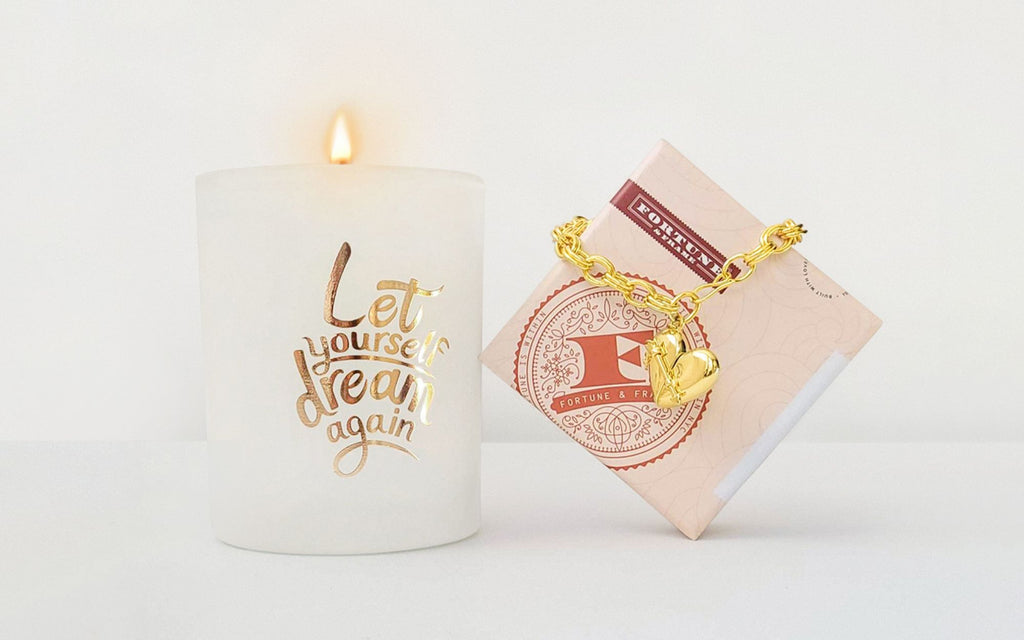 Let yourself dream again candle and Heart + Arrow Locket bracelet on the box.