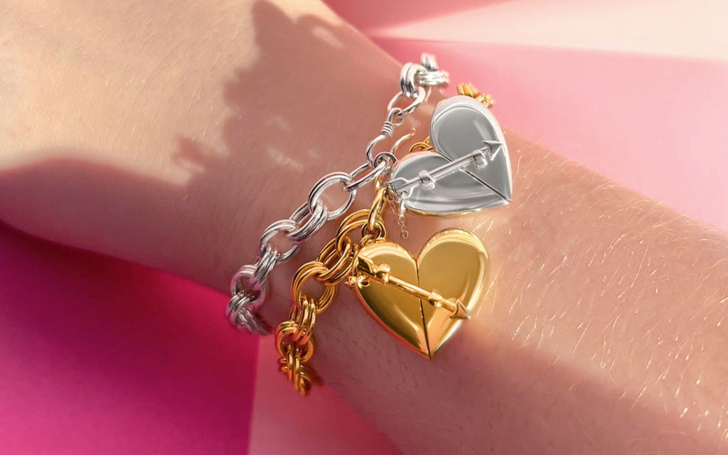 Silver and Gold Heart + Arrow bracelets on a wrist.