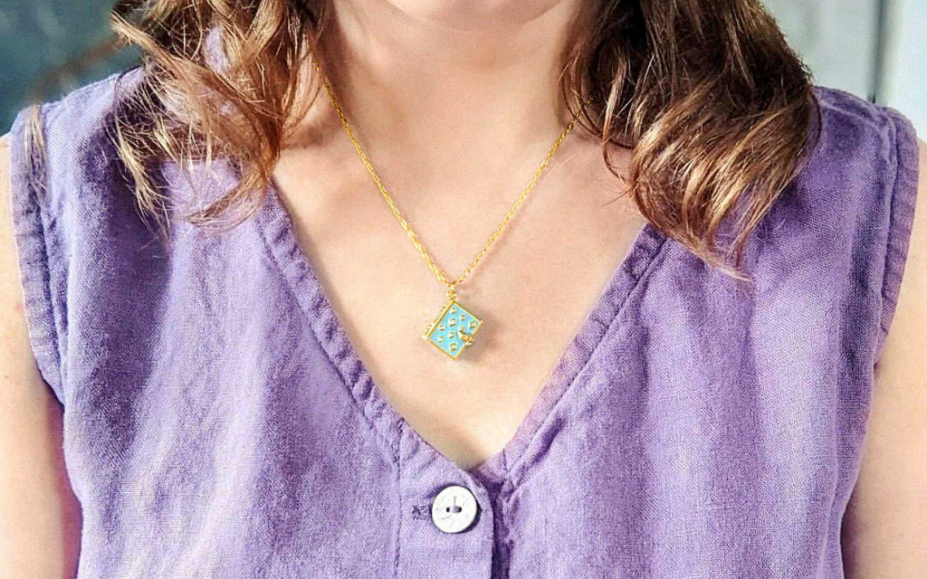 Author in purple shirt wearing her aquamarine stardust book locket