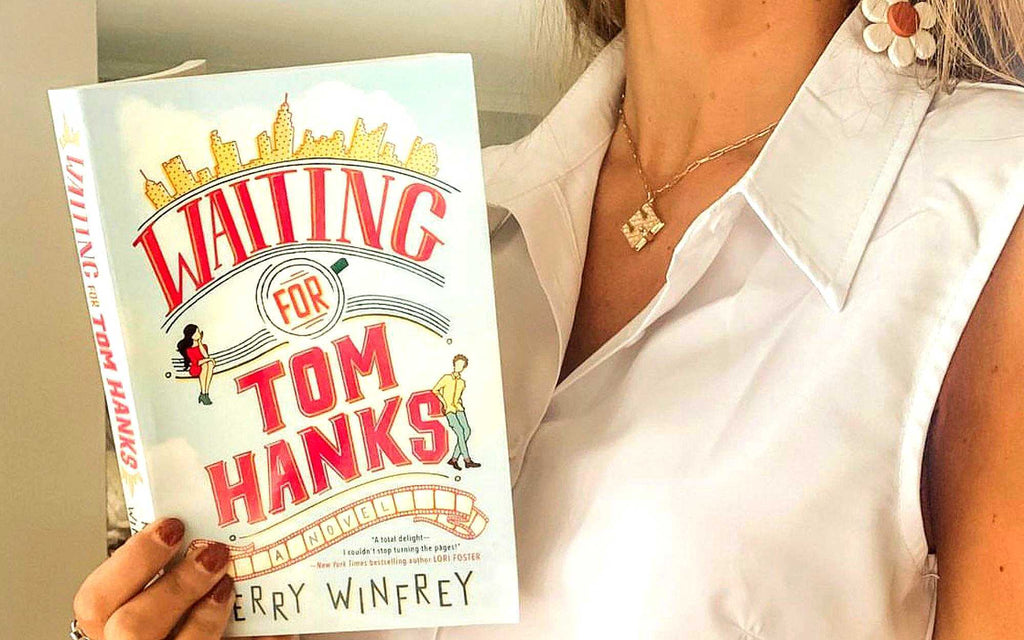 Book reader holding up "Waiting for Tom Hanks" book wearing her book locket