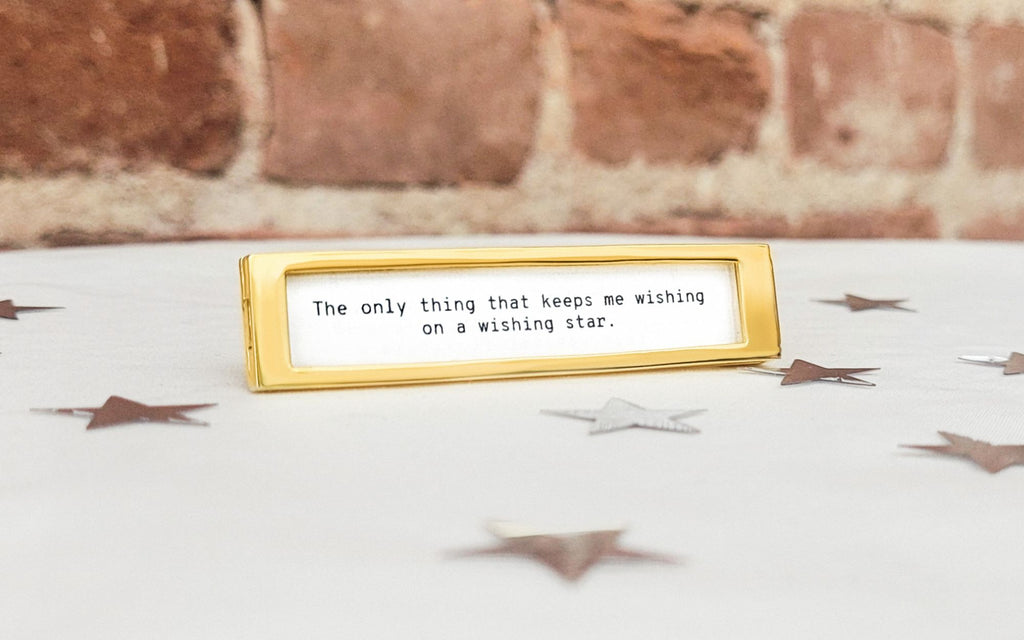Fortune Frame with a brick background and silver stars scattered on the white table.