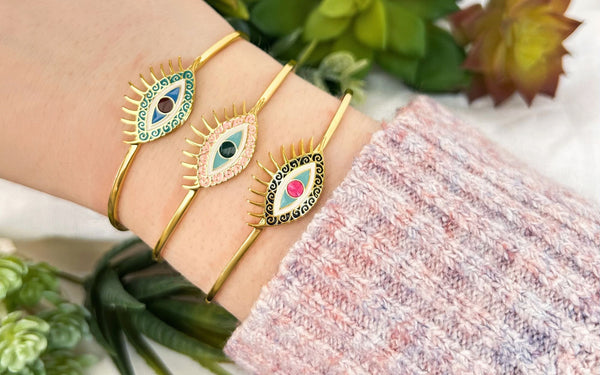 Wisdom, Vibrance, and Confidence Evil Eye Bracelets on wrist with plants.