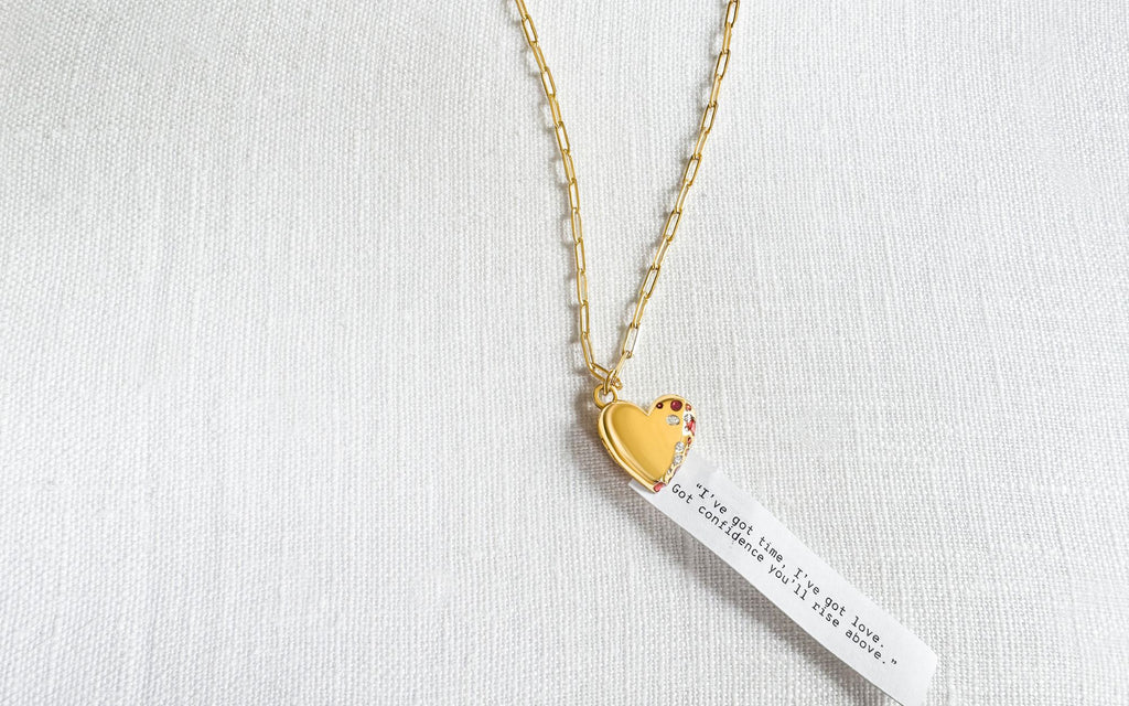 Jeweled Heart Locket on a white background with a fortune coming out of it that reads "“I've got time, I've got love. Got confidence you'll rise above.”