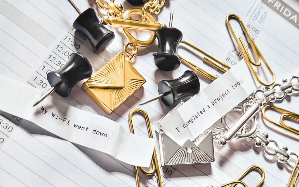 Love Letter Envelope Locket next to fortunes that read "My wi-fi went down" and "Icompelted a project today" surrounded by paperclips and thumb tacks,
