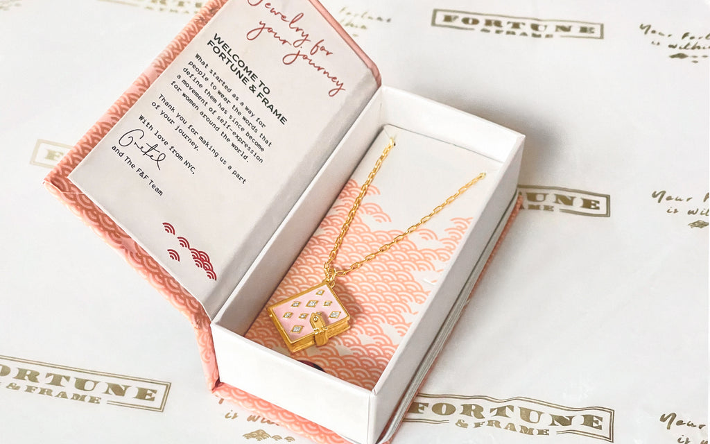 Blush stardust book locket inside a fortune & frame box with fortune & frame wrapping paper underneath.