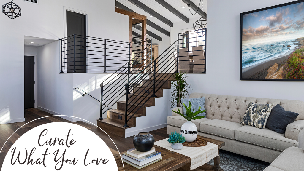 two story living room with framed photograph of cambria cove on the wall above the sofa