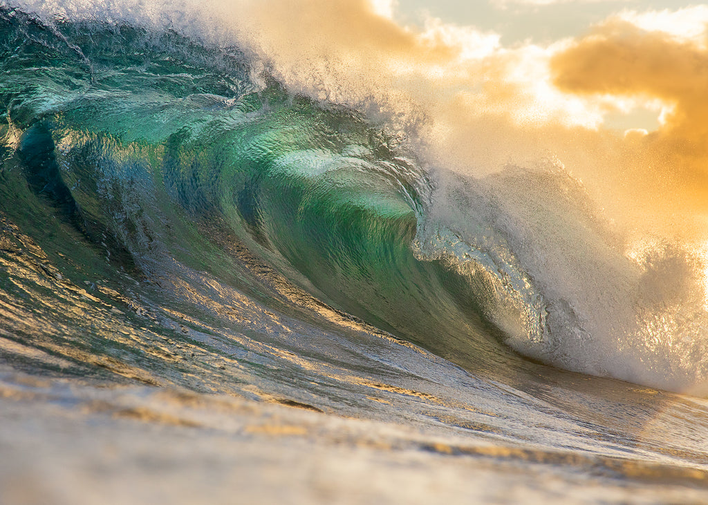 Ocean photograph of gold and turquoise colored wave cresting.