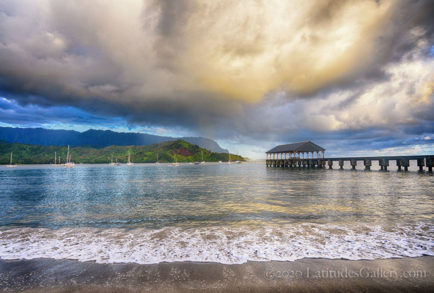 Hawaiian photograph of sunrise at Hanalei Bay with captivating overcast above calm island waters.