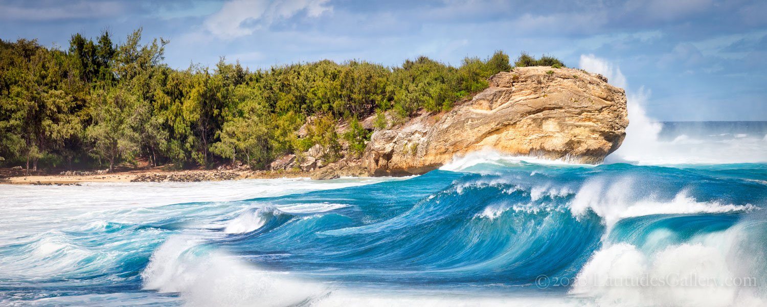 Turquoise blue ocean swell hitting the beach along Kauai's southside in Hawaii.