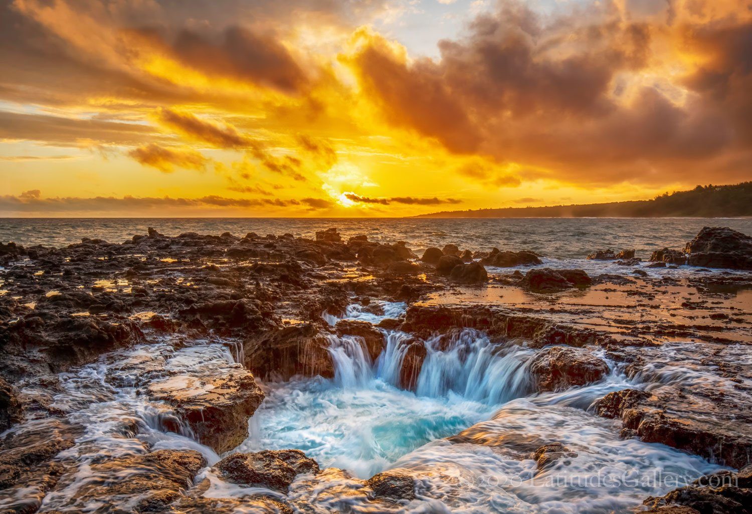 Office wall art photograph of an orange sunset above the North Shore of Kauai as water channels pour over jagged rocks.