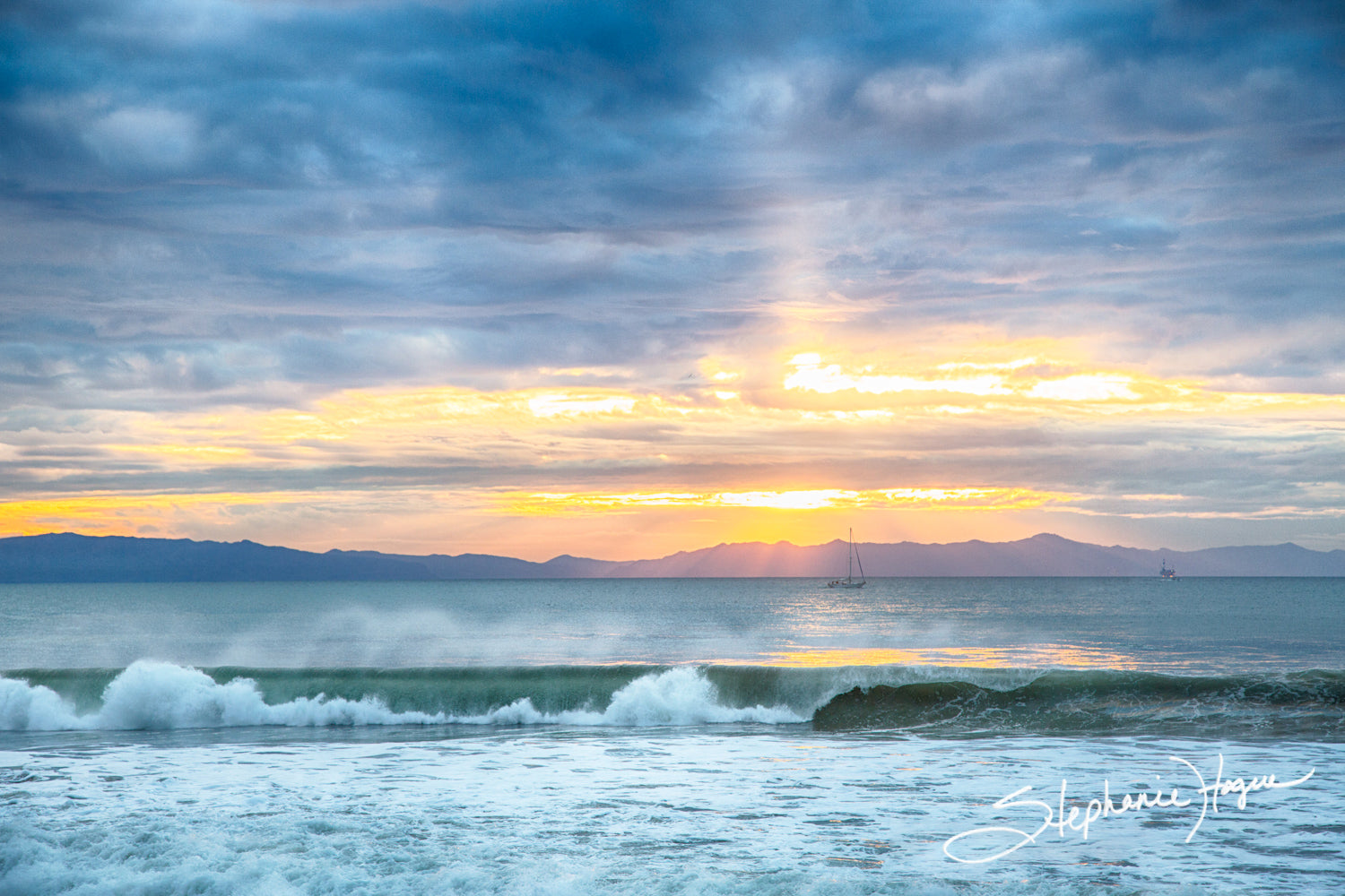 Oceanfront artwork of a beautiful cloudy sunset over the ocean featuring a sailboat.