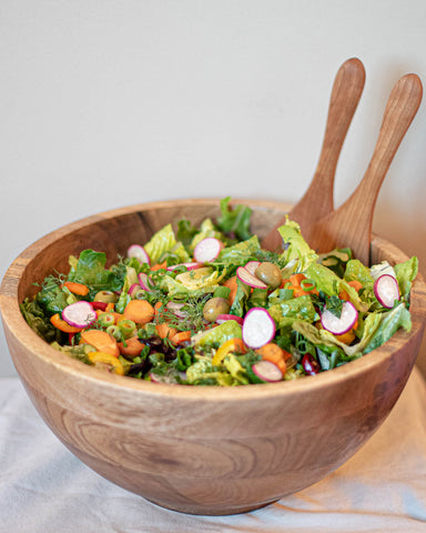 Simple Summer Greens Salad with Veggies in a Wooden Bowl with Wooden Serving Utensils