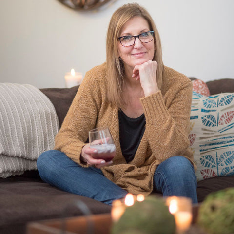 Gretchen (Christina) Maser sits on a couch with a glass of her Good Food Award Winner Red Raspberry Shrub. Christina Maser Co. is a woman-owned and operated small business in Lancaster, PA.