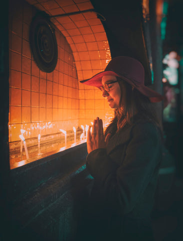 Woman praying in front of candles