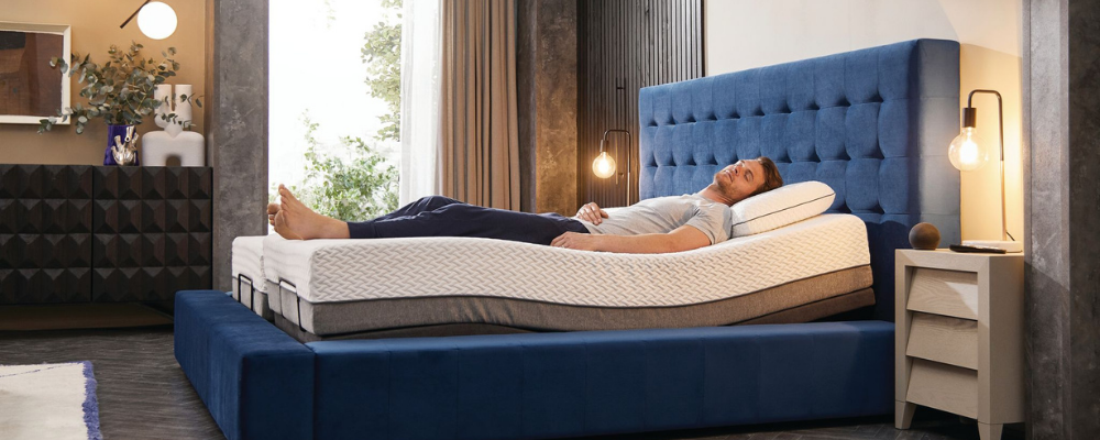 A person sleeping on an adjustable bed with their legs elevated