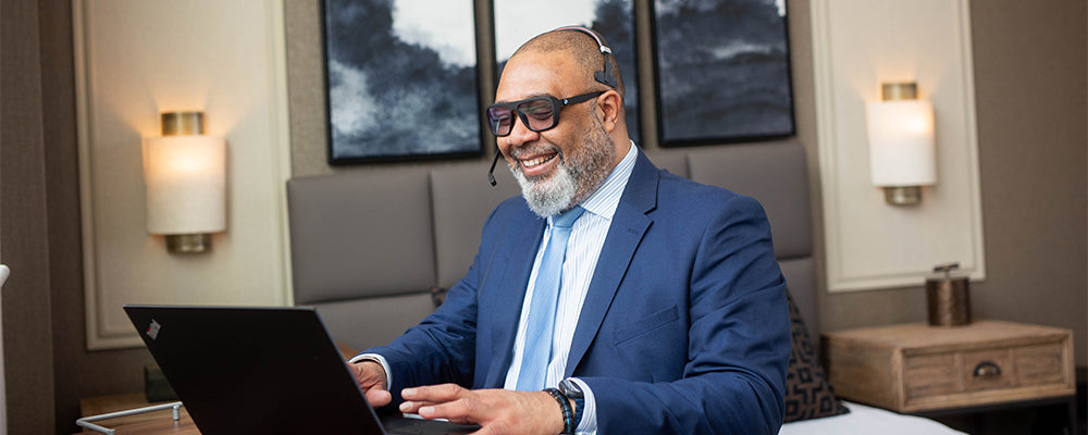 A sales person wearing a headset on a video call smiling