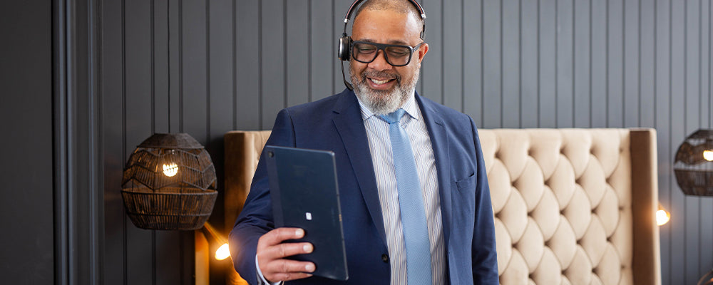 A sales man wearing a headset holding a tablet