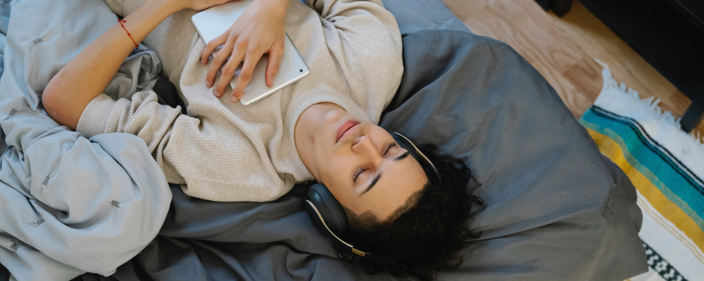 Can you learn while you sleep? Person in bed listening to something on their tablet.