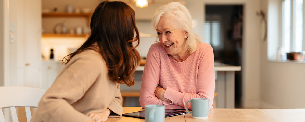 A older woman and daughter having a conversation at the kitchen table