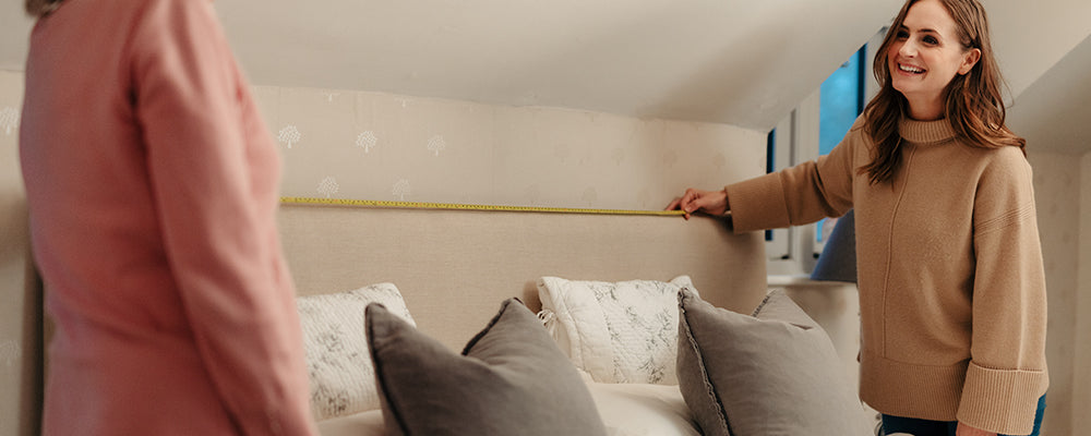 people measuring a bed