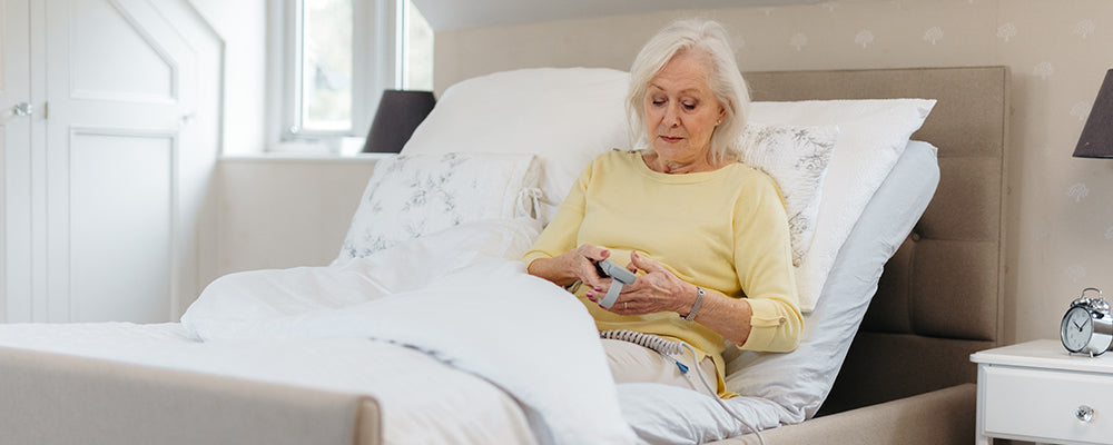 a lady adjusting her back rest on her bed