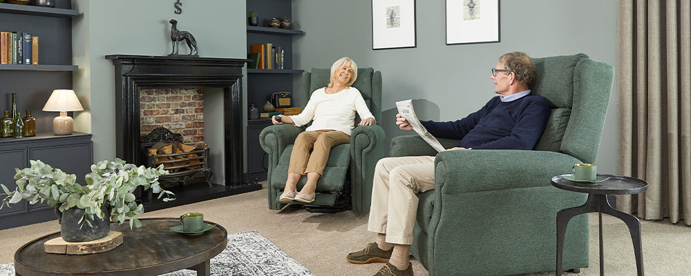 A husband and wife sat at home in a riser recliner chair