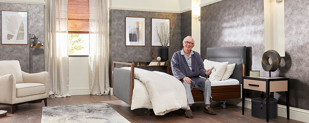 a man sat on the side of an adjustable bed