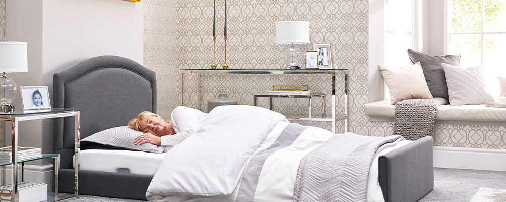 Older woman with blonde hair sleeping in a low profiling bed