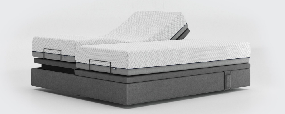 An undressed dual adjustable bed with one side adjusted so the user's legs are elevated