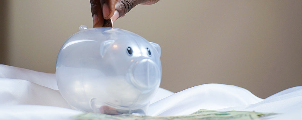 someone putting money into a piggy bank